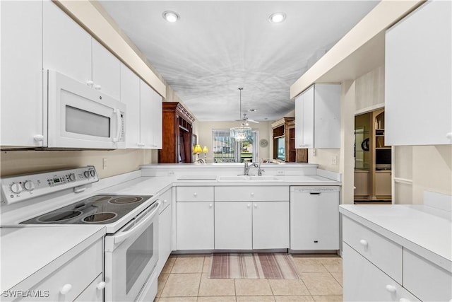 kitchen with pendant lighting, white appliances, sink, light tile patterned floors, and white cabinetry