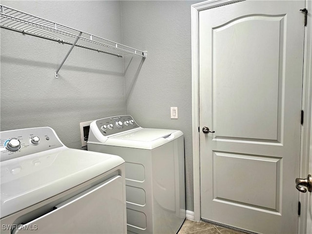 washroom with washer and clothes dryer and light tile patterned floors