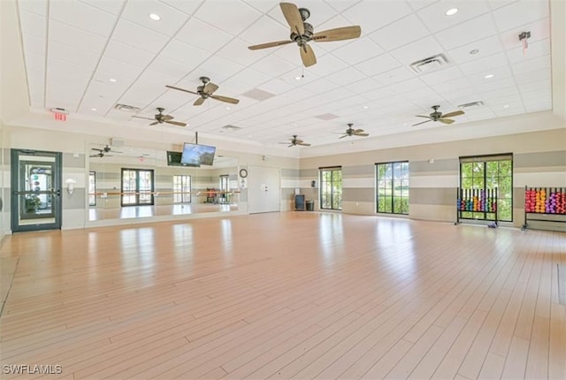 workout room with light wood-type flooring and a paneled ceiling