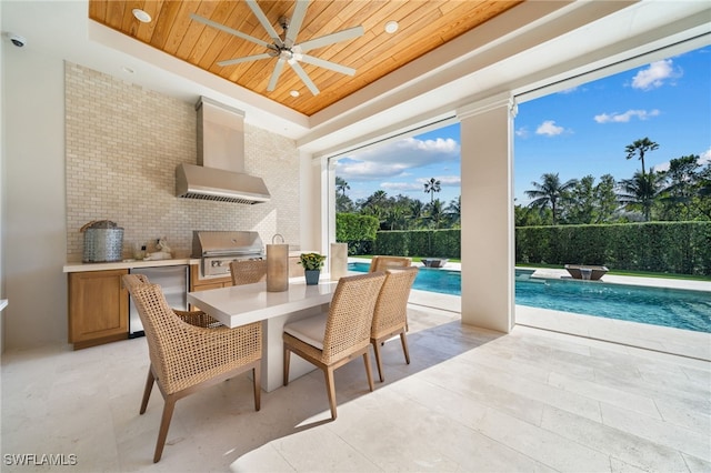 interior space featuring a fenced in pool, a ceiling fan, outdoor dining space, a grill, and exterior kitchen