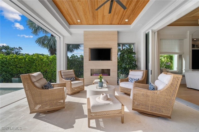 view of patio with ceiling fan and an outdoor living space with a fireplace