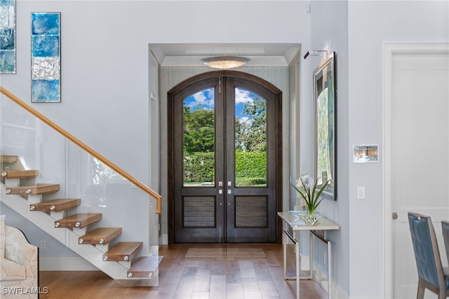 entryway with stairs, french doors, and wood finished floors