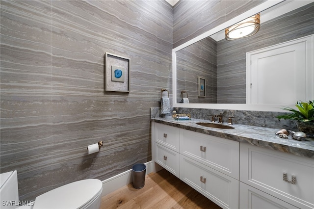 bathroom featuring wood finished floors, vanity, and toilet