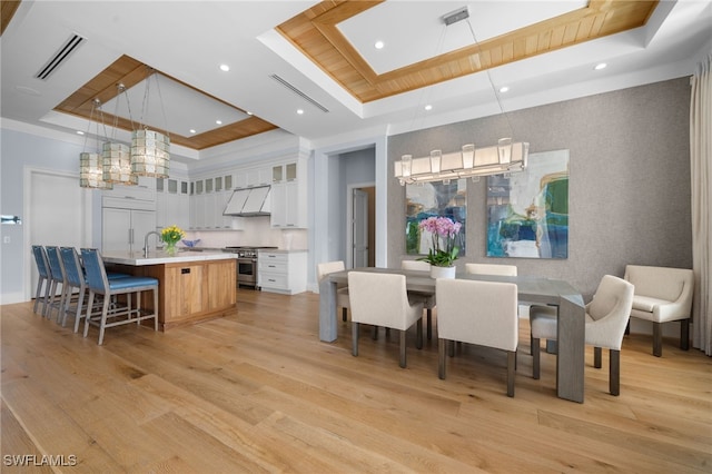 dining room with light wood-style floors, recessed lighting, a raised ceiling, and visible vents