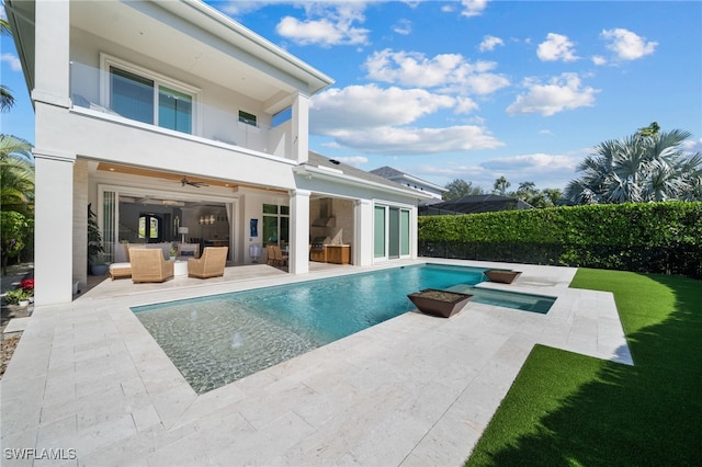 rear view of property with stucco siding, an outdoor hangout area, a ceiling fan, a patio area, and a balcony