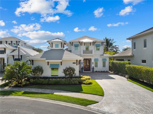 view of front of property with decorative driveway, a tiled roof, and stucco siding