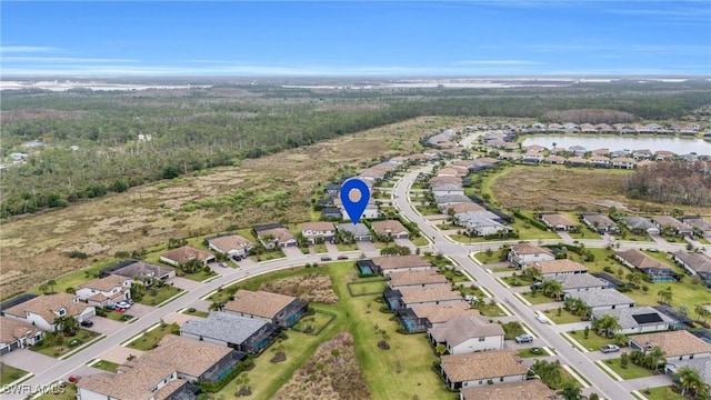 17250 Ashcomb Way, Estero, FL 33928 - aerial view of property's location featuring nearby suburban area, a large body of water, and a heavily wooded area