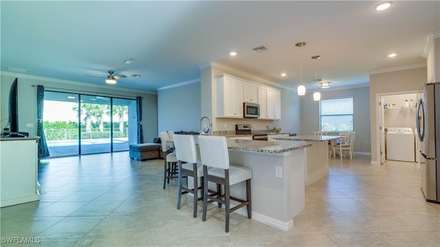 kitchen with ceiling fan, pendant lighting, white cabinetry, light stone countertops, and appliances with stainless steel finishes