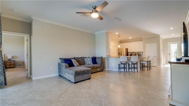 tiled living room with ceiling fan and crown molding