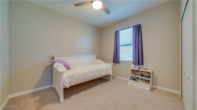 carpeted bedroom featuring ceiling fan and a closet