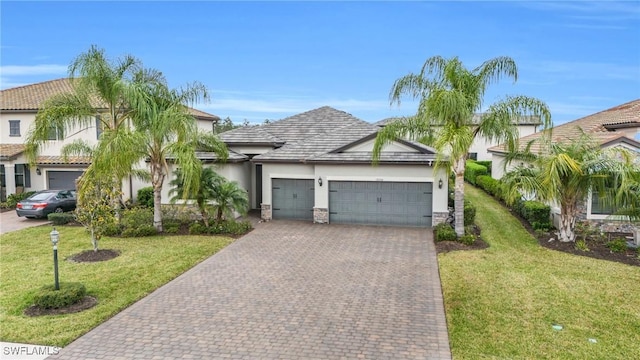 17250 Ashcomb Way, Estero, FL 33928 - view of front facade with an attached garage, decorative driveway, stucco siding, stone siding, and a front yard