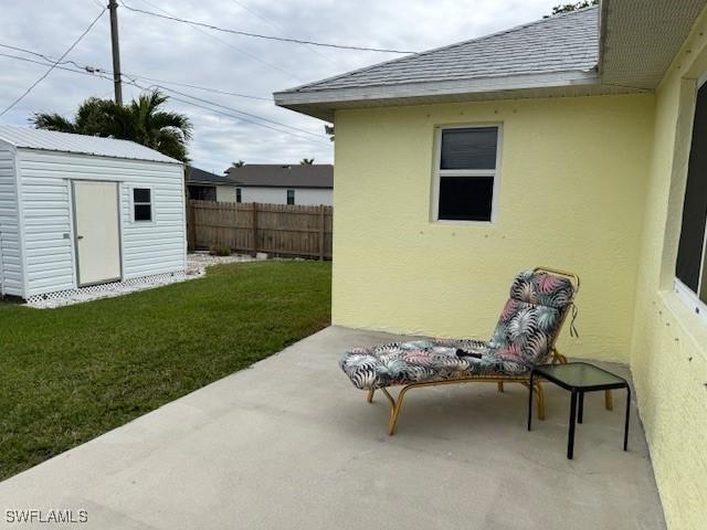 view of patio / terrace with a storage shed, an outdoor structure, and fence