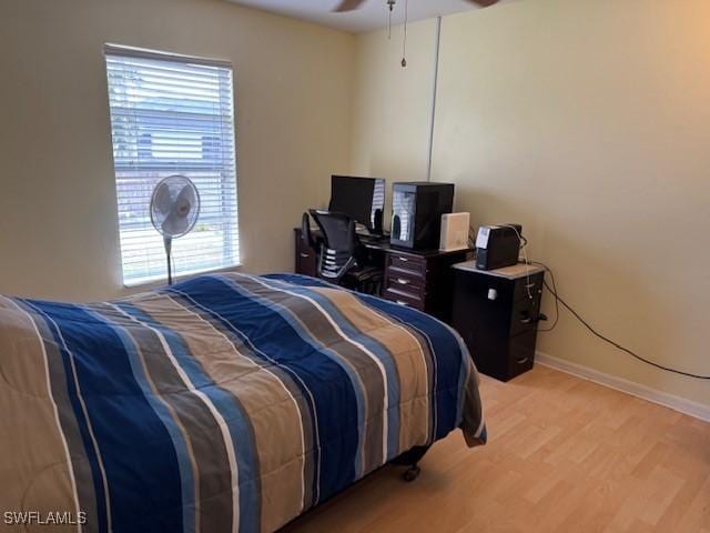 bedroom featuring light wood-style floors, ceiling fan, and baseboards