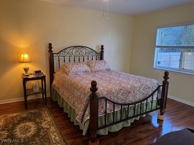 bedroom with baseboards and wood finished floors