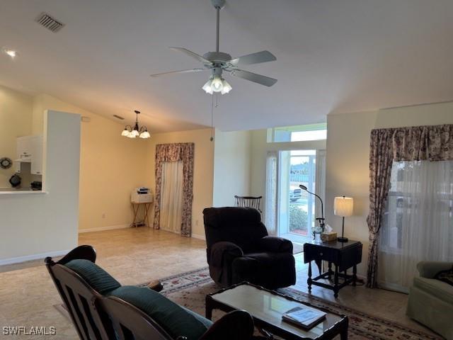 living room with baseboards, visible vents, vaulted ceiling, and ceiling fan with notable chandelier