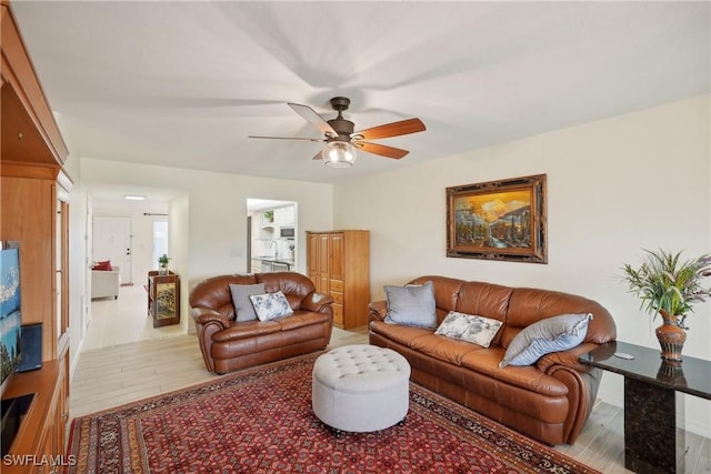 living room with ceiling fan and light hardwood / wood-style flooring