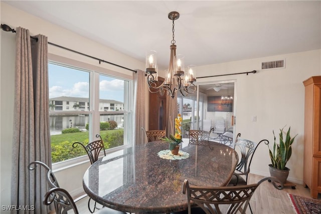 dining space with plenty of natural light, a chandelier, and light hardwood / wood-style flooring