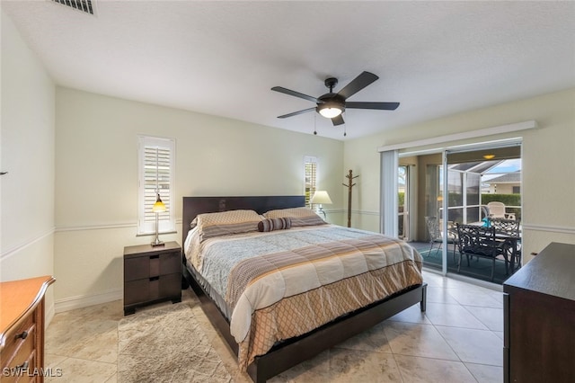 tiled bedroom featuring ceiling fan, access to exterior, and multiple windows