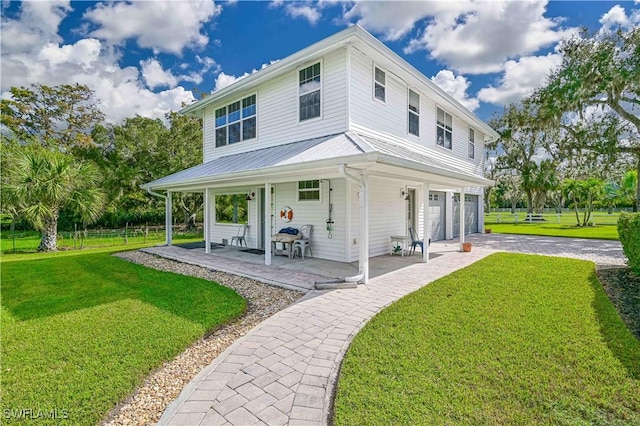 back of property featuring a porch, a garage, and a lawn