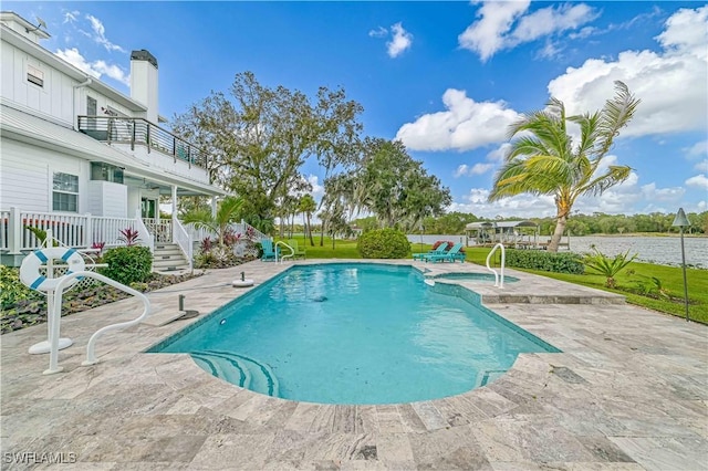 view of swimming pool featuring a water view and a patio