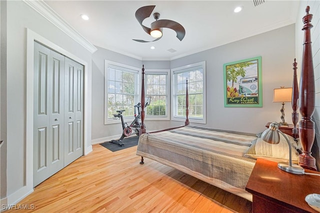 bedroom featuring ceiling fan, a closet, ornamental molding, and light wood-type flooring