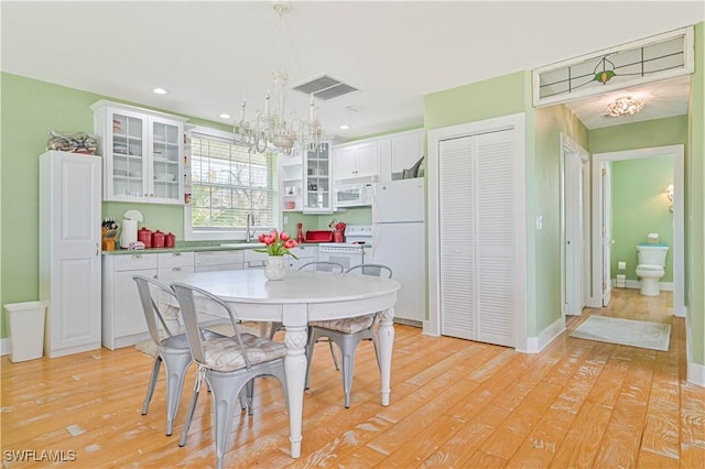 dining room featuring light hardwood / wood-style floors, sink, and a notable chandelier