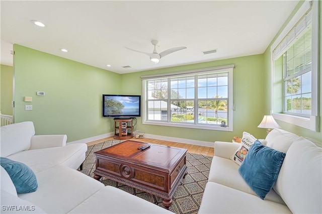 living room featuring light hardwood / wood-style floors and ceiling fan