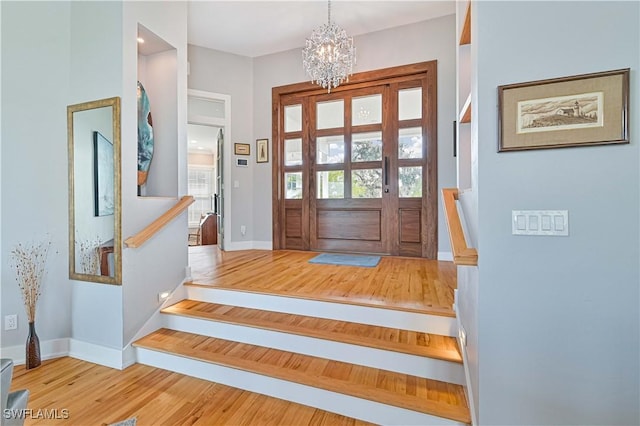 foyer featuring light wood-type flooring and a notable chandelier