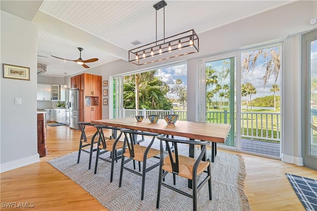 dining area featuring ceiling fan, beam ceiling, and light hardwood / wood-style floors