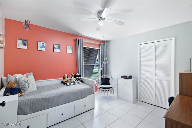 bedroom with light tile patterned floors, a closet, and ceiling fan