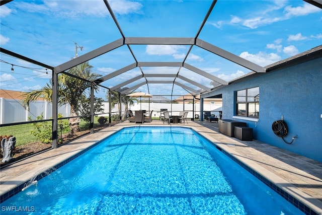 view of pool featuring glass enclosure and a patio