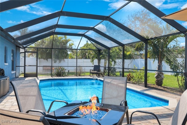 view of swimming pool featuring a lanai, a patio, and a fire pit