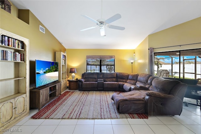 living room with ceiling fan, plenty of natural light, light tile patterned floors, and lofted ceiling