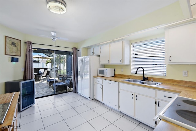 kitchen featuring white appliances, white cabinets, sink, ceiling fan, and light tile patterned flooring