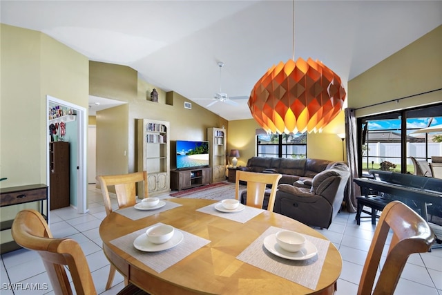 dining space featuring ceiling fan, lofted ceiling, and light tile patterned floors