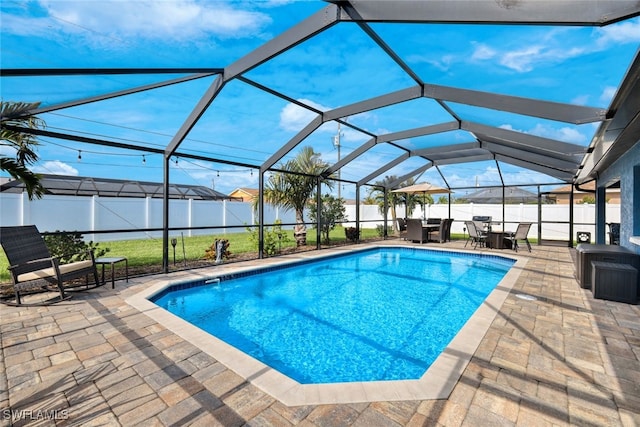 view of pool featuring glass enclosure and a patio area