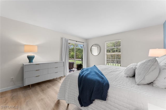 bedroom featuring access to exterior and light hardwood / wood-style floors