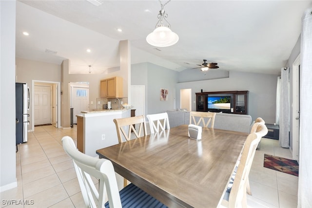 dining room featuring light tile patterned floors, vaulted ceiling, ceiling fan, and sink