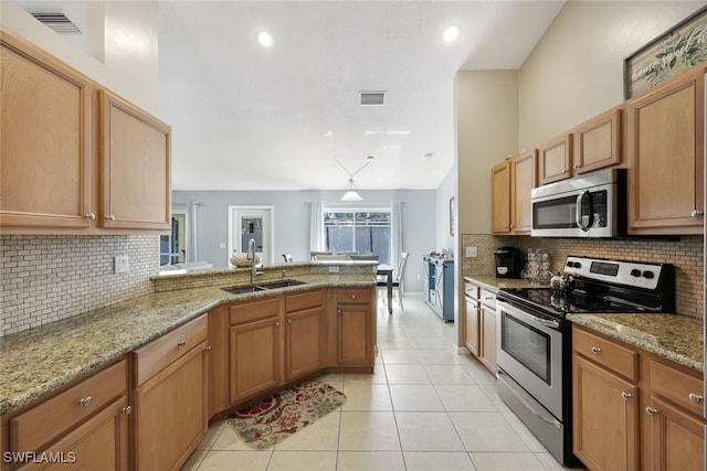 kitchen featuring kitchen peninsula, light stone countertops, stainless steel appliances, sink, and light tile patterned flooring