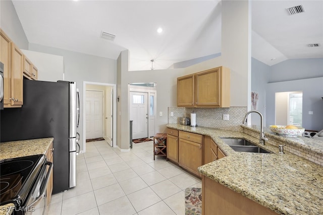 kitchen with sink, light stone counters, kitchen peninsula, vaulted ceiling, and light tile patterned floors