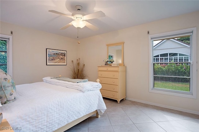 bedroom featuring ceiling fan, multiple windows, and light tile patterned floors