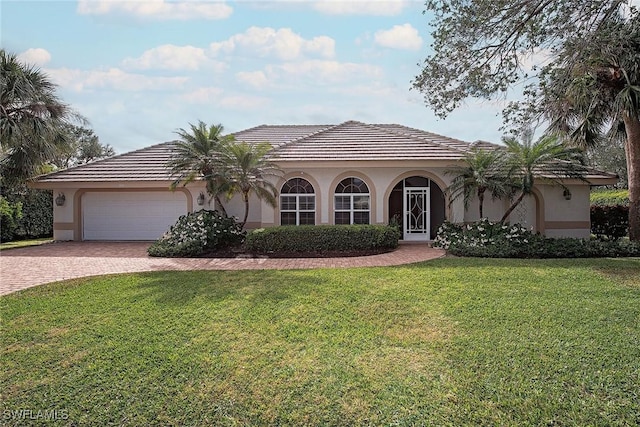 mediterranean / spanish home with a garage and a front yard