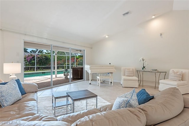 living room with a sunroom, visible vents, vaulted ceiling, and light tile patterned flooring