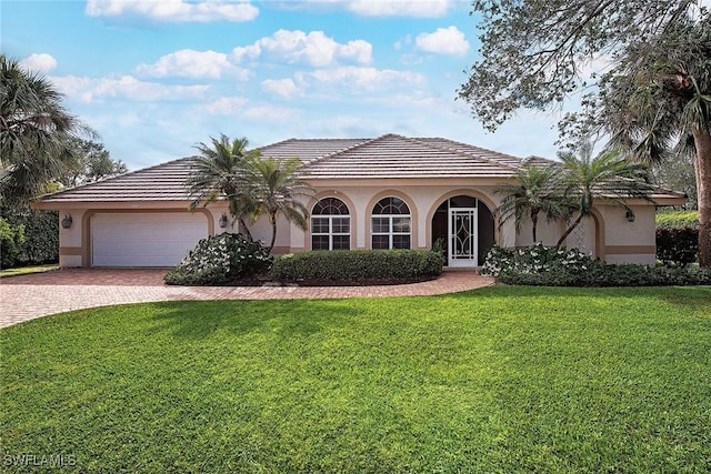 view of front facade featuring a garage, decorative driveway, a front lawn, and stucco siding