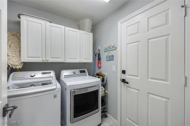 laundry area featuring cabinet space, washer and clothes dryer, and baseboards