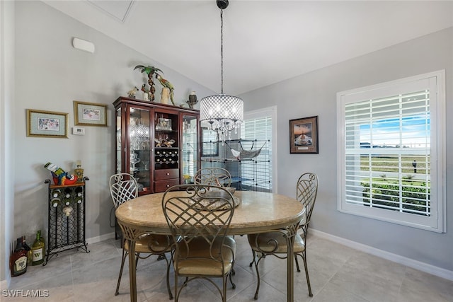 dining space with lofted ceiling, light tile patterned floors, an inviting chandelier, and baseboards