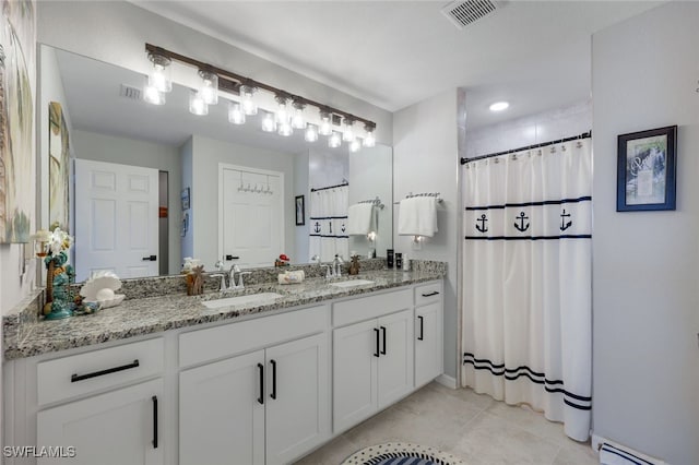 full bath with a baseboard heating unit, visible vents, a sink, and tile patterned floors