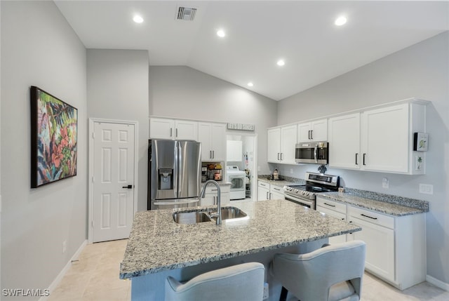 kitchen featuring appliances with stainless steel finishes, an island with sink, a sink, and white cabinets