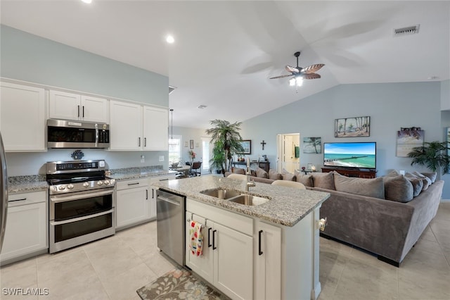 kitchen featuring visible vents, appliances with stainless steel finishes, open floor plan, white cabinetry, and a sink