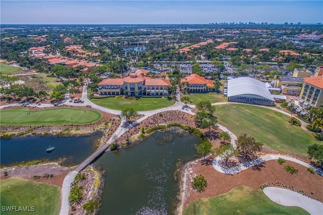 drone / aerial view with view of golf course and a water view